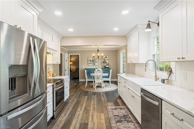 kitchen featuring a sink, dark wood-style floors, stainless steel appliances, white cabinets, and a chandelier