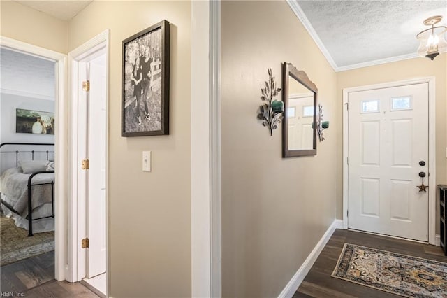 entryway featuring a textured ceiling, crown molding, baseboards, and dark wood-style flooring