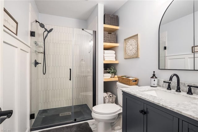 full bathroom featuring vanity, toilet, and a shower stall