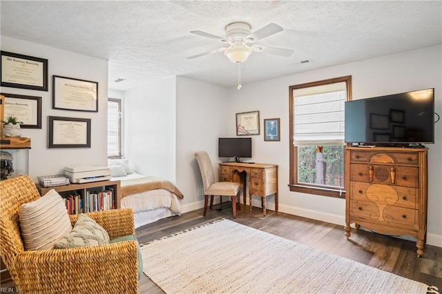 office area featuring visible vents, baseboards, a textured ceiling, and wood finished floors