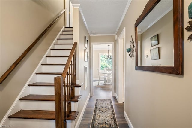 interior space with crown molding, baseboards, a chandelier, wood finished floors, and a textured ceiling