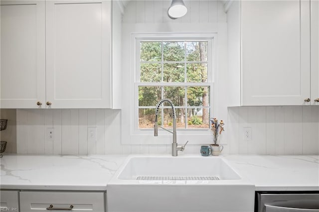 kitchen with a wealth of natural light, white cabinetry, and a sink