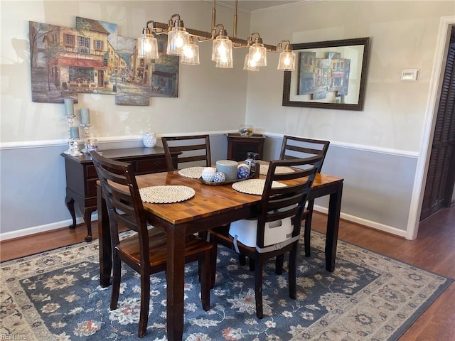 dining area with ornamental molding, baseboards, and wood finished floors