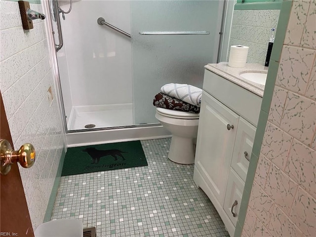 full bath featuring toilet, a stall shower, tile walls, tile patterned flooring, and vanity