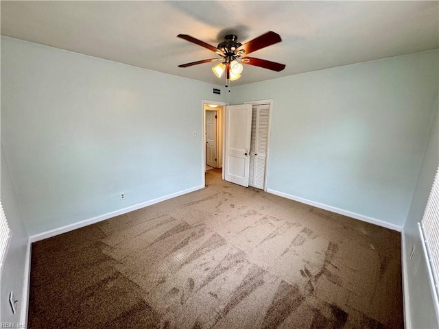 unfurnished bedroom featuring carpet floors, visible vents, baseboards, and a closet