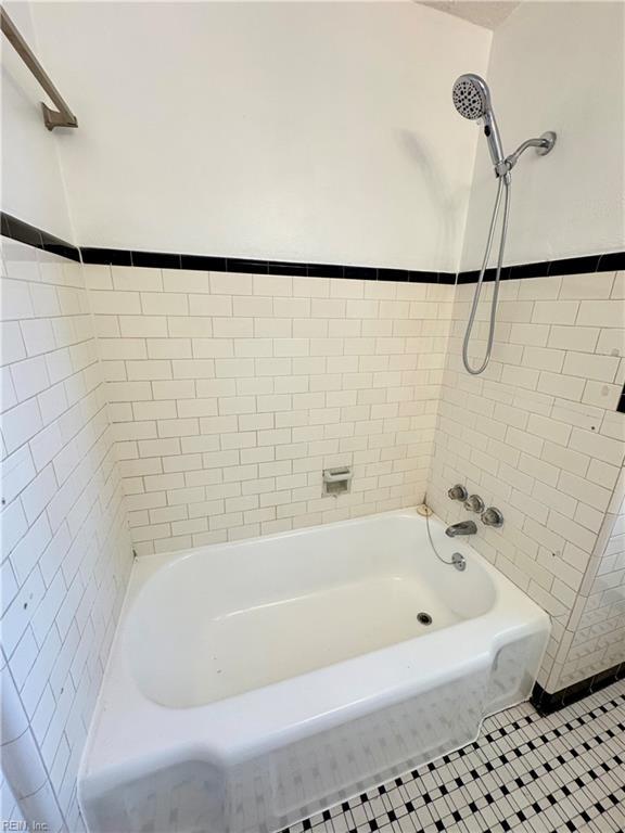 bathroom with bathing tub / shower combination, tile walls, and tile patterned floors