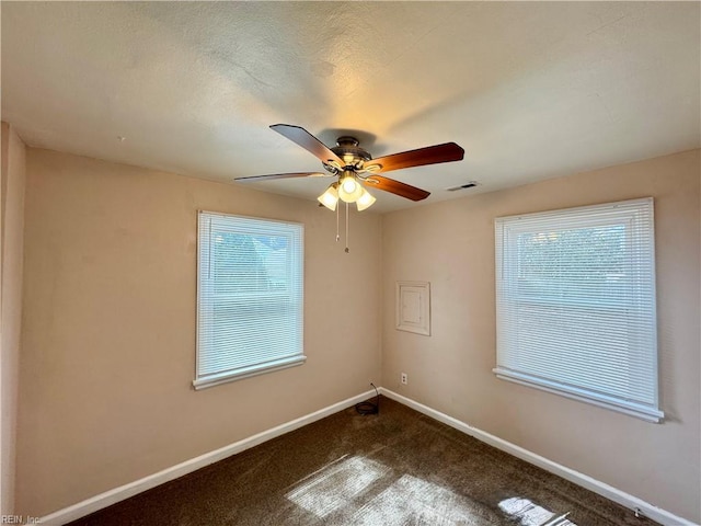 unfurnished room with carpet floors, visible vents, baseboards, and a ceiling fan