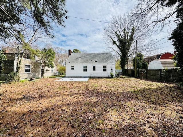 back of house with a patio, a chimney, and fence