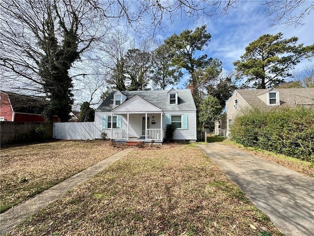 cape cod-style house with covered porch and fence