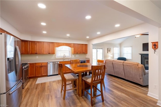 kitchen featuring recessed lighting, light countertops, light wood-style flooring, appliances with stainless steel finishes, and a sink