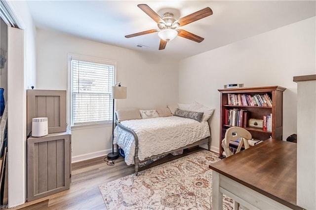 bedroom with visible vents, ceiling fan, baseboards, and wood finished floors