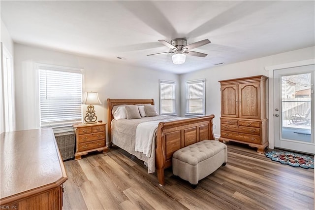 bedroom with access to exterior, multiple windows, visible vents, and light wood finished floors