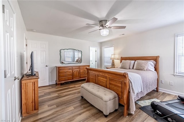 bedroom with a ceiling fan, visible vents, light wood-style flooring, and baseboards