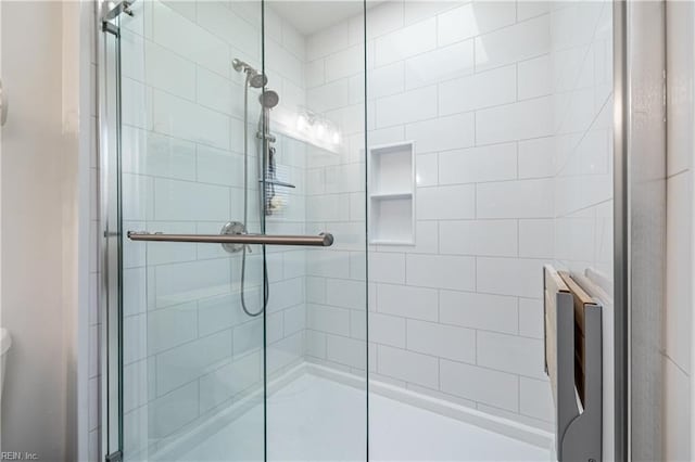 bathroom featuring a stall shower and toilet