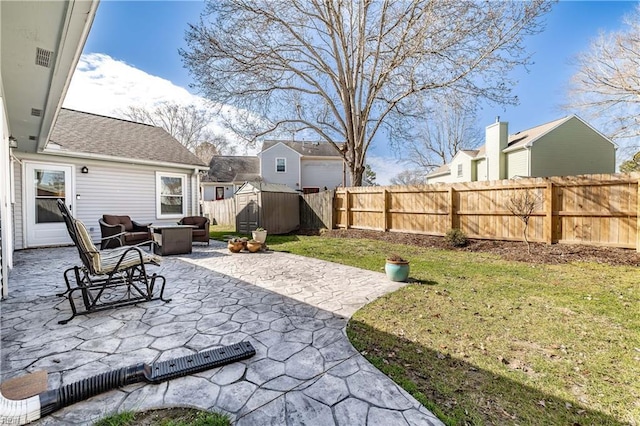 view of yard featuring an outdoor living space with a fire pit, a patio, a fenced backyard, an outbuilding, and a shed