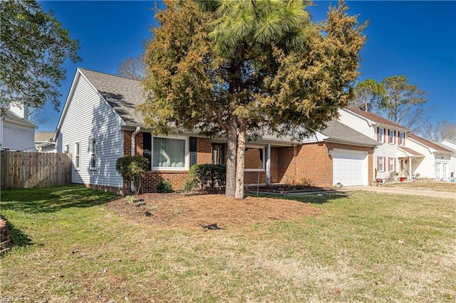 view of front facade with brick siding, a front yard, fence, a garage, and driveway