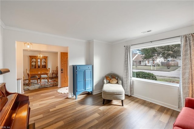 sitting room featuring ornamental molding, wood finished floors, visible vents, and baseboards