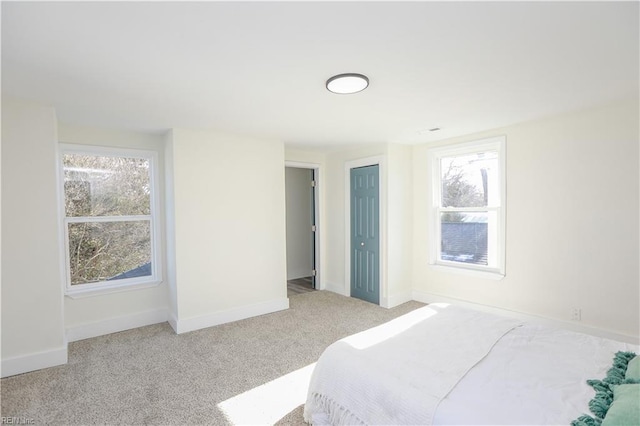 bedroom with multiple windows, baseboards, and carpet flooring