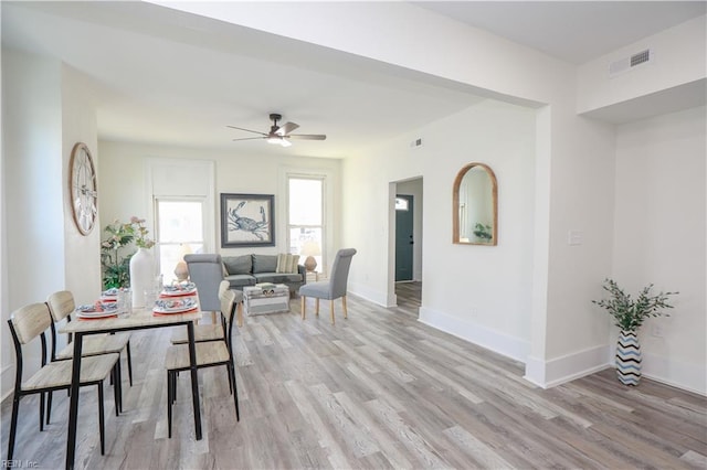 dining area featuring baseboards, ceiling fan, visible vents, and light wood-style floors