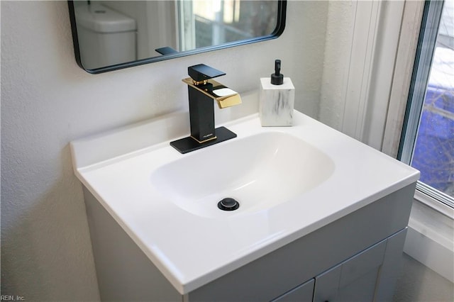 bathroom with a textured wall and vanity