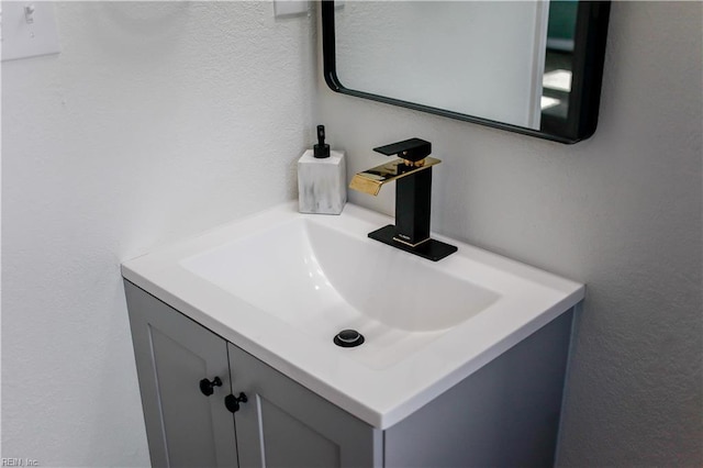 bathroom featuring a textured wall and vanity