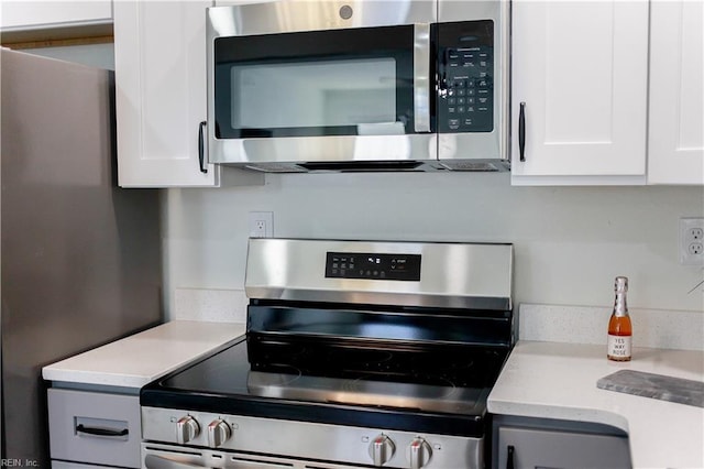 kitchen with light countertops, appliances with stainless steel finishes, and white cabinets