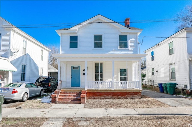 view of front of property with covered porch and a chimney