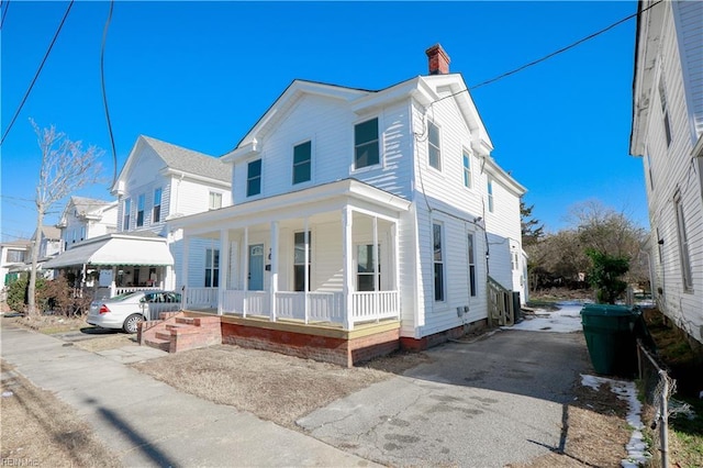 view of front of property featuring covered porch and a chimney