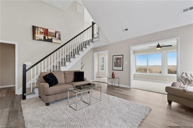 living room featuring visible vents, wood finished floors, and stairway