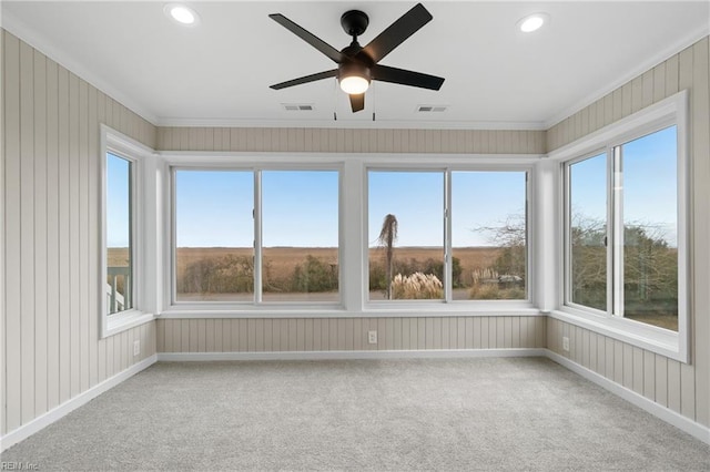 unfurnished sunroom featuring a healthy amount of sunlight, visible vents, and ceiling fan