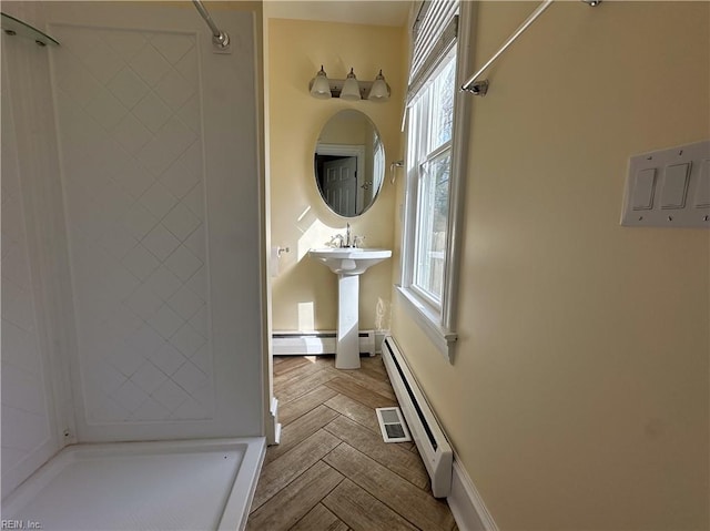 bathroom with a shower and baseboard heating