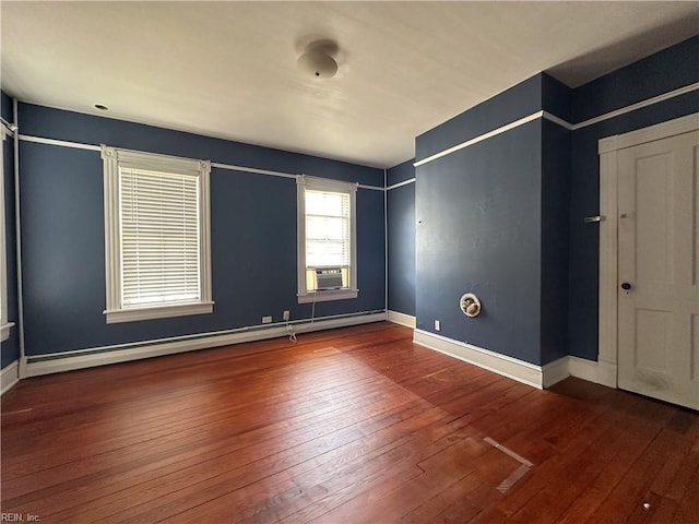 unfurnished bedroom featuring hardwood / wood-style flooring, baseboards, baseboard heating, and cooling unit