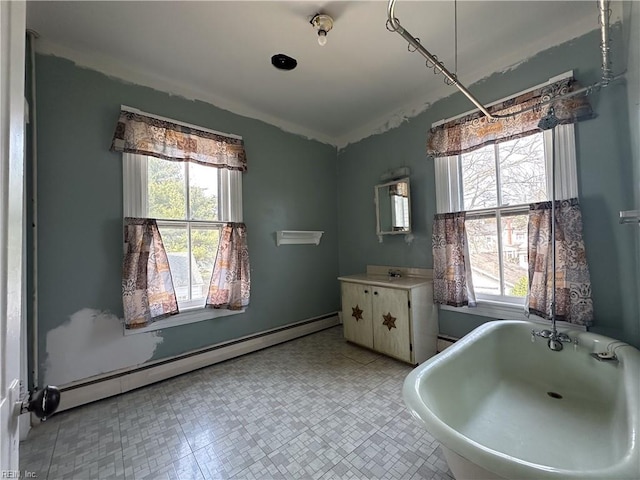 bathroom featuring a baseboard radiator, a freestanding bath, and vanity