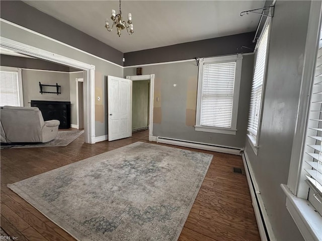 interior space featuring a baseboard radiator, dark wood finished floors, a fireplace, and an inviting chandelier