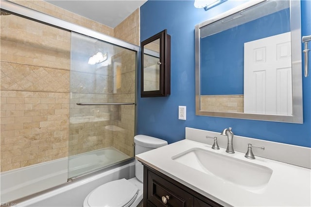 full bathroom with vanity, toilet, and bath / shower combo with glass door