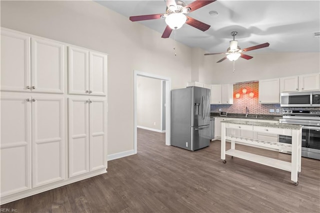 kitchen with baseboards, stainless steel appliances, dark wood-type flooring, white cabinetry, and backsplash