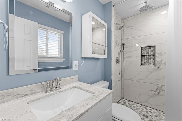 full bath featuring a marble finish shower, toilet, and vanity