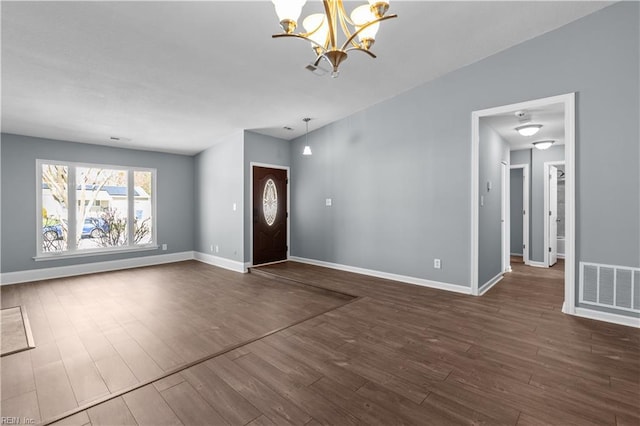 entryway featuring a notable chandelier, visible vents, dark wood-style flooring, and baseboards