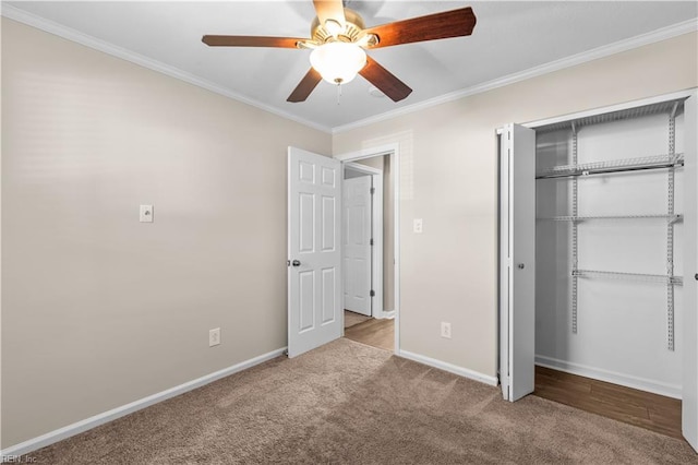 unfurnished bedroom with crown molding, baseboards, carpet floors, a closet, and a ceiling fan