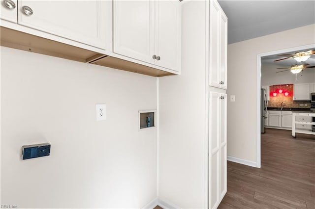 washroom with baseboards, dark wood finished floors, cabinet space, ceiling fan, and washer hookup