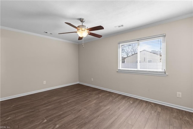 empty room with visible vents, ornamental molding, baseboards, and wood finished floors