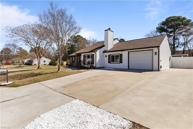 view of front of property featuring a front yard, fence, driveway, an attached garage, and a chimney