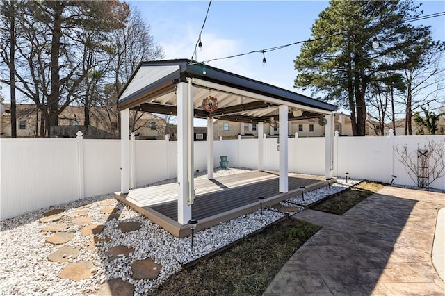 wooden terrace with a gazebo and a fenced backyard