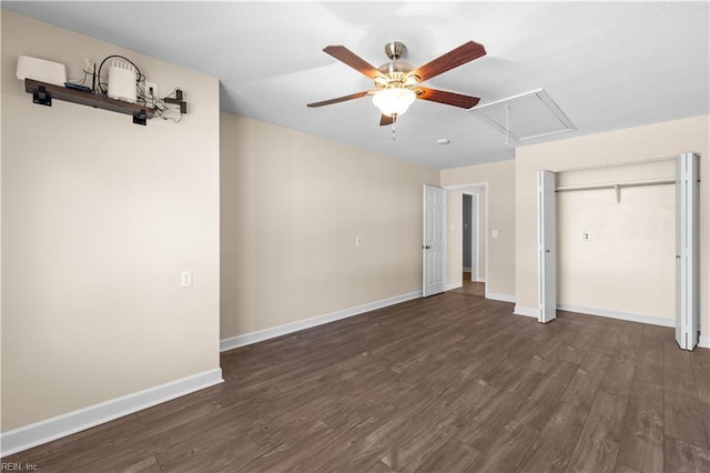 unfurnished bedroom with ceiling fan, baseboards, attic access, and wood finished floors