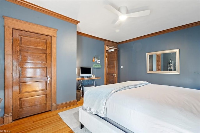 bedroom featuring a ceiling fan, crown molding, wood finished floors, and baseboards