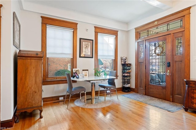 interior space featuring baseboards, wood finished floors, and ornamental molding