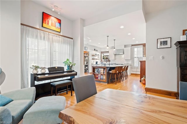 dining area featuring light wood finished floors, recessed lighting, and baseboards