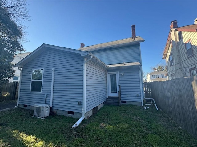 back of house with entry steps, crawl space, and a lawn