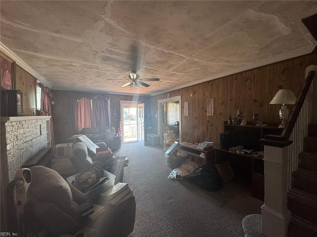 miscellaneous room with ceiling fan, stairway, ornamental molding, carpet floors, and wood walls