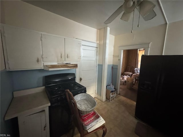 kitchen with white cabinets, a ceiling fan, under cabinet range hood, light countertops, and black appliances